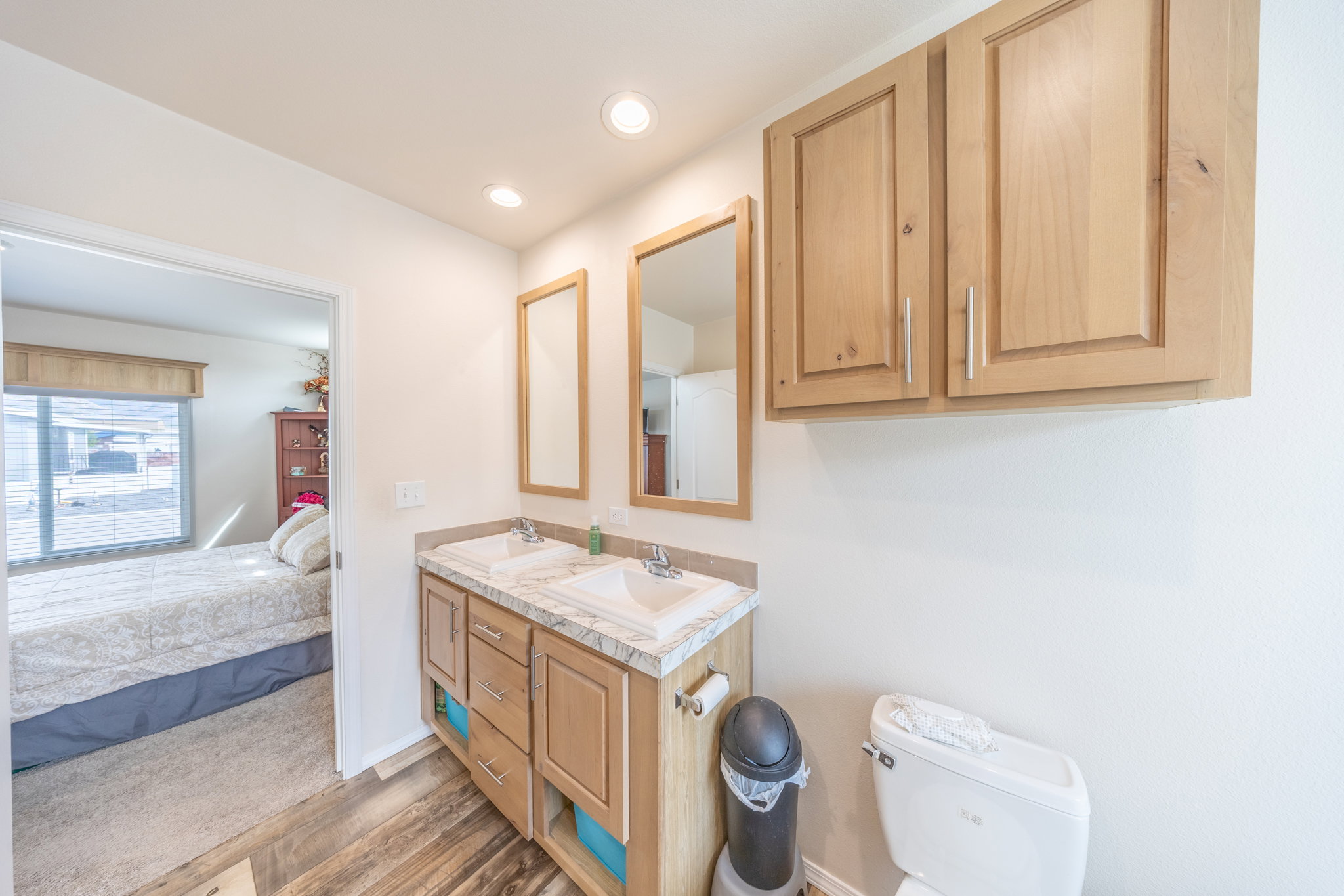 Full bath featuring double vanity, connected bathroom, light wood-type flooring, and recessed lighting
