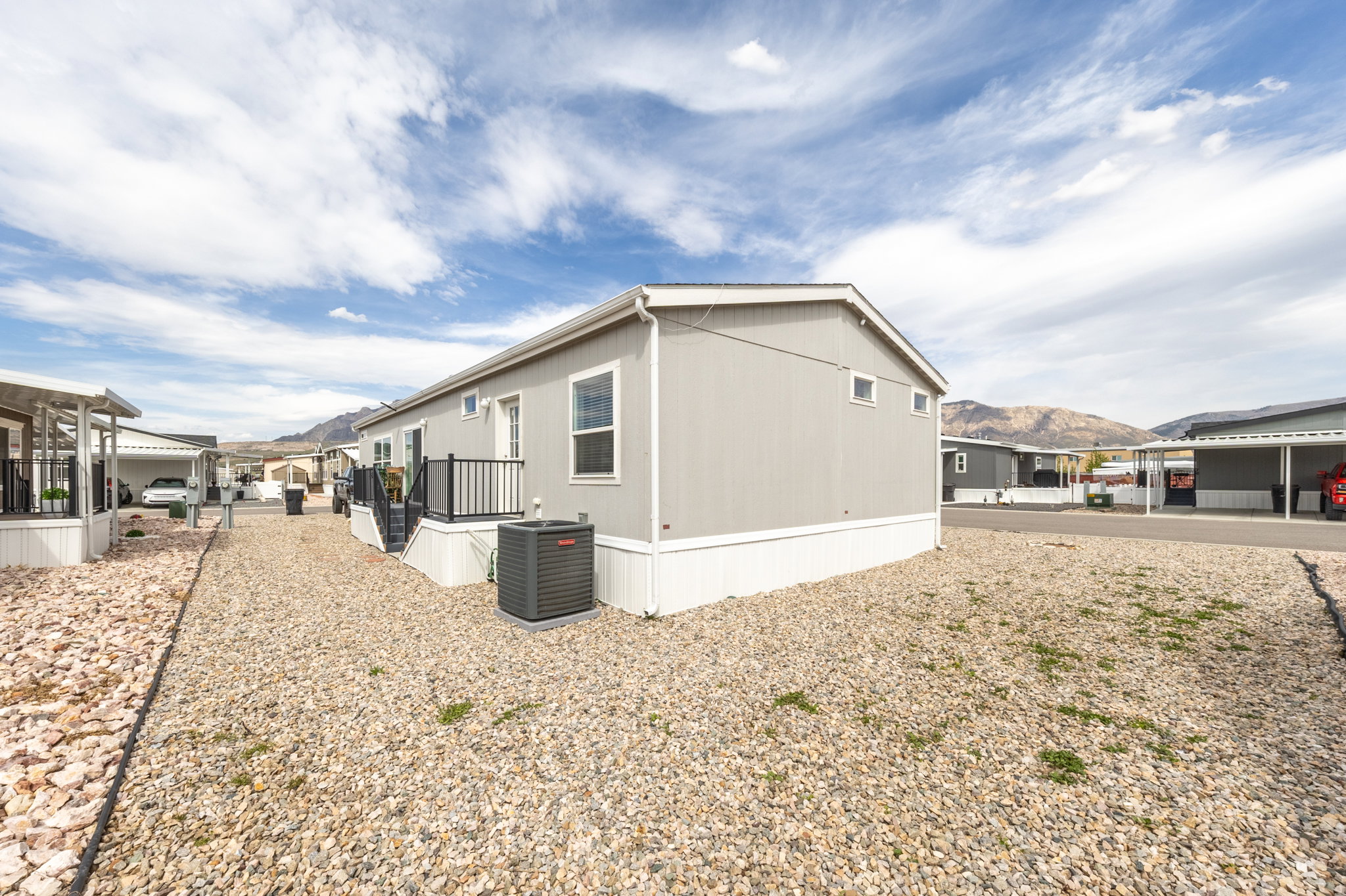 View of property exterior featuring a mountain view and a central air condition unit