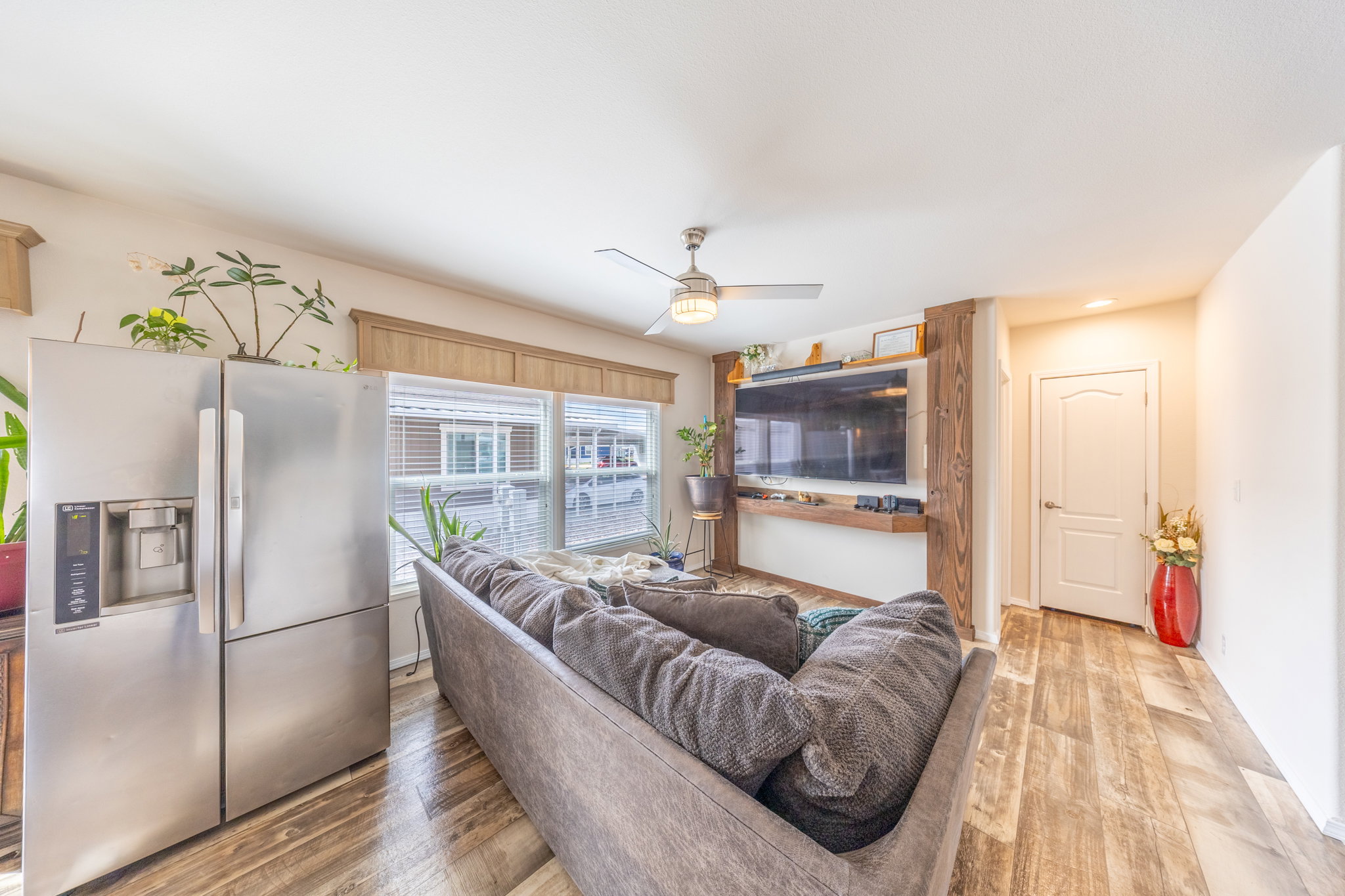 Living area featuring light wood-type flooring, a ceiling fan, and recessed lighting