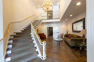 Stairs featuring a high ceiling, crown molding, and suspended lighting