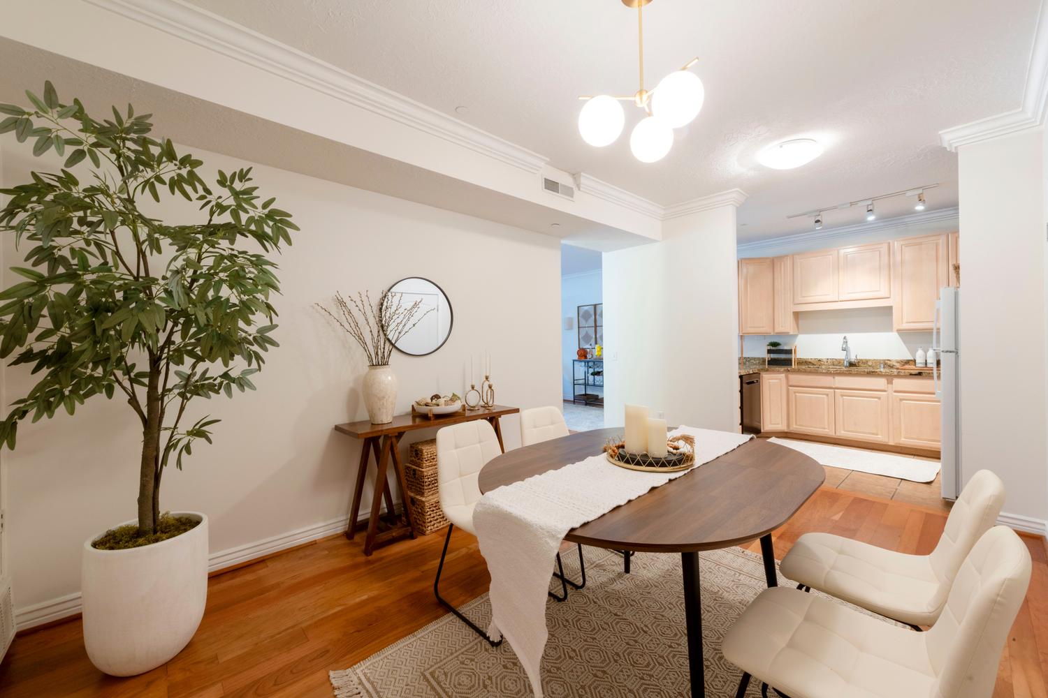 Dining area featuring wood-finish flooring, crown molding, and a contemporary spherical light fixture