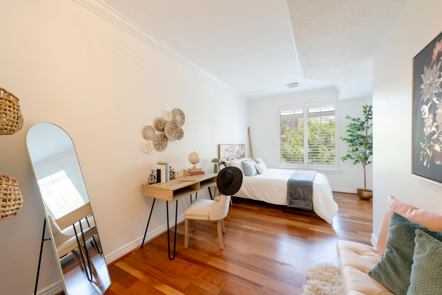 Bright interior space featuring wood-finish flooring, white walls, and crown molding