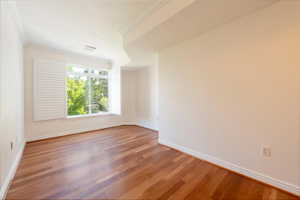 Spare room with wood finished floors and ornamental molding
