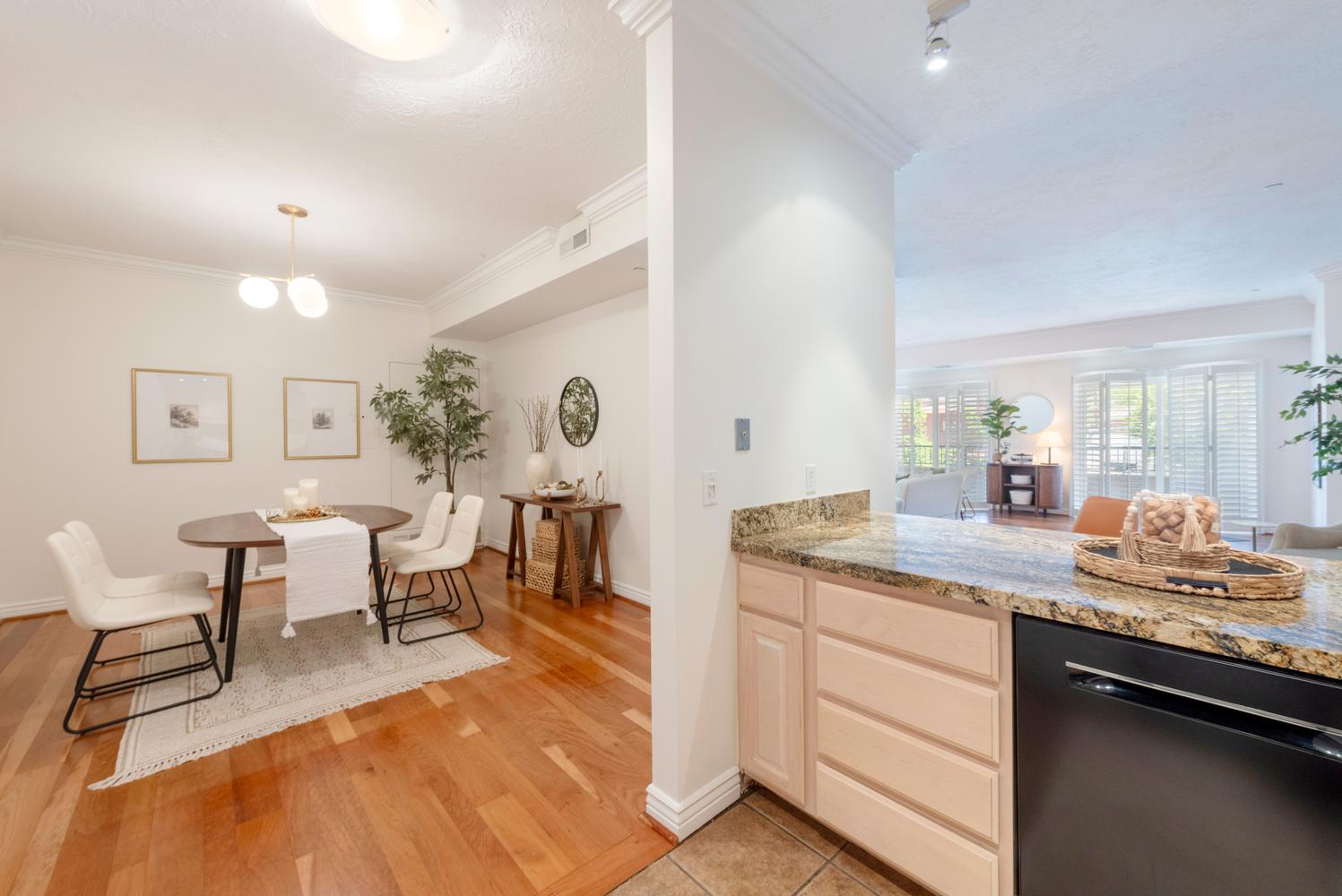 Dedicated dining area featuring wood-finish flooring, crown molding, and a modern ceiling light fixture
