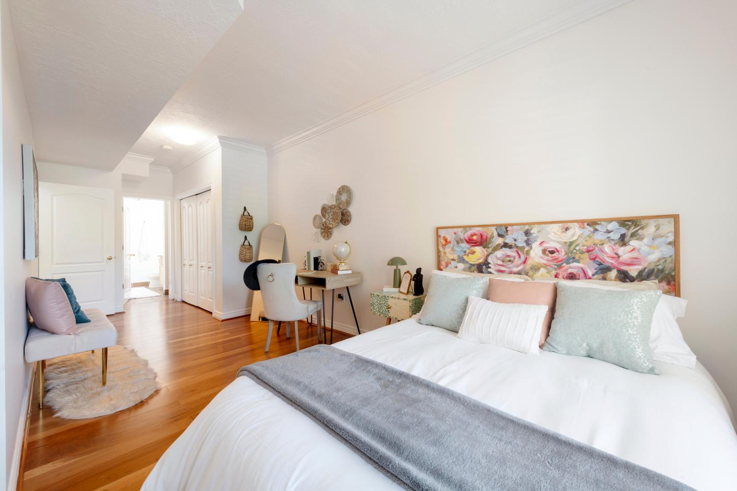 Bright room featuring wood-finish flooring, white walls, and crown molding