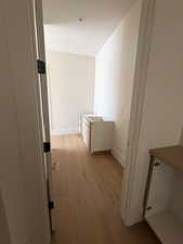 Hall with light wood-style floors and an upstairs landing