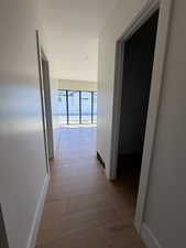Hallway with light wood-style flooring and recessed lighting