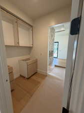 Laundry room with light wood finished floors and baseboards