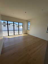 Spare room with baseboards and dark wood-type flooring