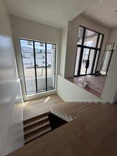 Stairway with wood finished floors and healthy amount of natural light