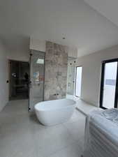 Bathroom featuring a shower stall and a freestanding tub