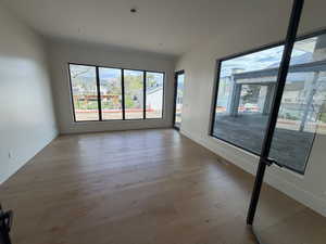 Empty room with baseboards and light wood-type flooring