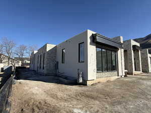 View of property exterior featuring stone siding and stucco siding