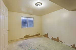 Unfurnished room with a textured ceiling