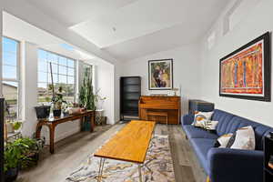 Living room with lofted ceiling and wood finished floors