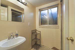 Full bath with a textured ceiling and a shower with door