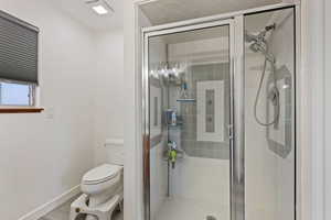 Bathroom with a shower stall and light wood finished floors