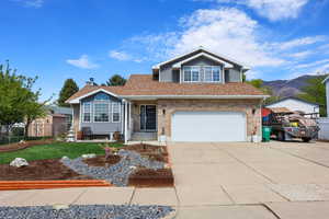 View of front of house with concrete driveway, a garage, brick siding, roof with shingles, and a chimney