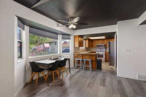 Dining room with light wood finished floors and ceiling fan
