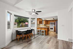 Dining room with light wood finished floors and a ceiling fan