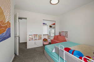 Bedroom with dark colored carpet and crown molding
