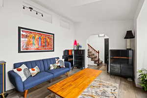 Living area with arched walkways and wood finished floors