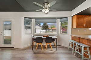 Dining space with light wood-type flooring, a ceiling fan, and a mountain view