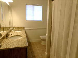 Master Full bath featuring double vanity, light tile patterned flooring, and curtained shower