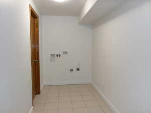 Laundry area featuring hookup for a washing machine, light tile patterned floors, hookup for a gas dryer, and electric dryer hookup