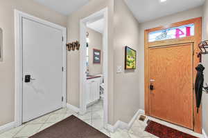 Foyer entrance featuring light tile patterned flooring and baseboards
