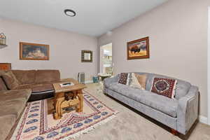 Living area featuring carpet flooring and radiator heating unit