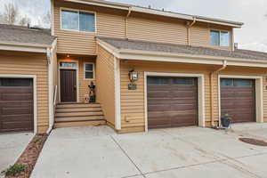View of front of home with roof with shingles, driveway, and an attached garage