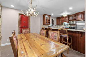 Dining room featuring hanging lights and light colored carpet