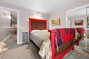 Carpeted bedroom featuring a closet