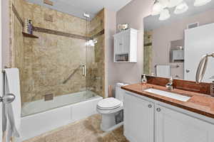 Bathroom featuring vanity, shower / bath combination with glass door, and light tile patterned floors