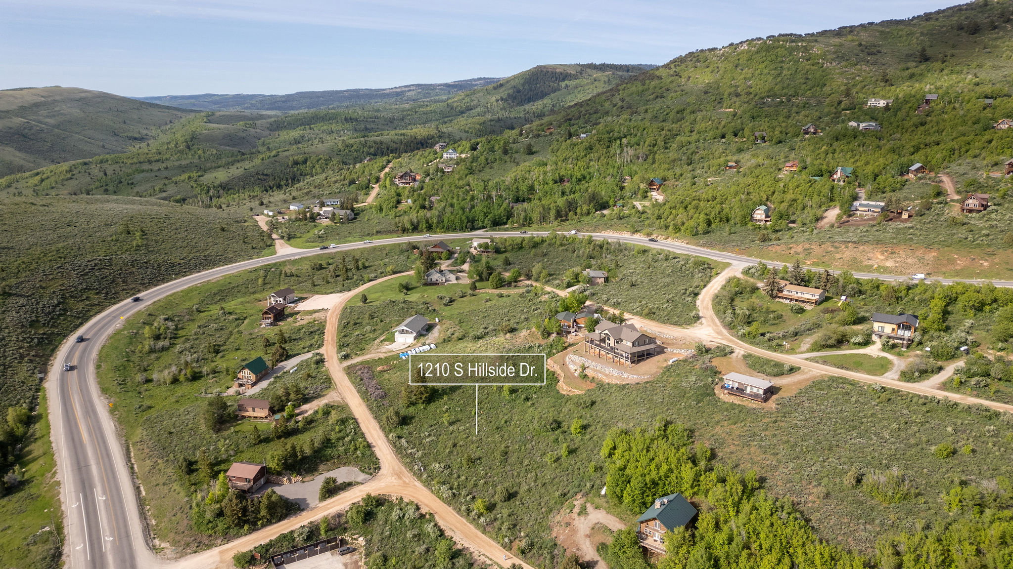 Aerial view of property and surrounding area featuring property parcel outlined and a mountain backdrop