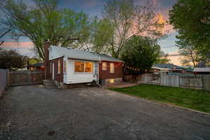 Bungalow-style house with a gate, a chimney, a patio, a fenced backyard, and brick siding