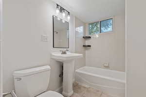 Full bath featuring bathtub / shower combination and light tile patterned flooring