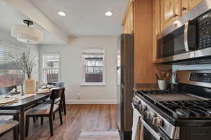 Kitchen with stainless steel appliances, dark wood-type flooring, and recessed lighting