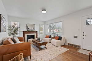 Living room featuring a tile fireplace and wood finished floors
