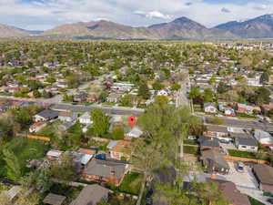 Aerial view of property and surrounding area featuring nearby suburban area and a mountainous background