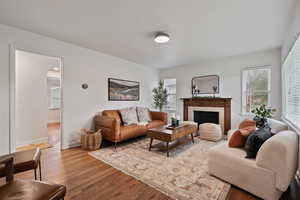 Living room with wood finished floors, healthy amount of natural light, arched walkways, and a fireplace