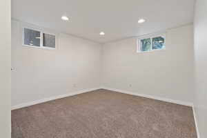 Below grade area with dark colored carpet and recessed lighting