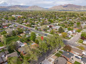 Aerial view of property and surrounding area featuring nearby suburban area and a mountain backdrop