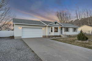 Ranch-style house with driveway, a shingled roof, and a garage