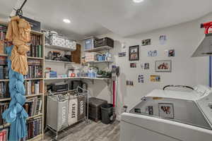 Laundry area featuring washer / dryer, light wood-type flooring, and recessed lighting