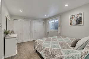 Carpeted bedroom featuring two closets and recessed lighting
