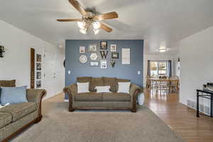Living room with wood finished floors and a ceiling fan