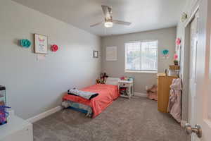 Bedroom with light colored carpet and a ceiling fan