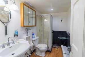 Bathroom with light wood-type flooring, a shower stall, and recessed lighting